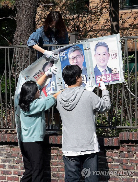 17일 서울 종로구 동숭동에서 서울시 선거관리위원회 관계자들이 서울시 교육감 보궐선거 벽보를 철거하고 있다. 연합뉴스